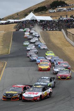 a group of cars driving down a race track