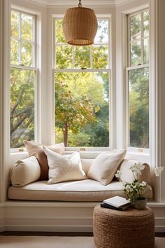 a window seat with pillows on it next to a basket