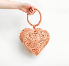 Hand woven bag in iraca palm designed with a heart shape, with handle.  Designed to make the end of your week more stylish.  - Handmade in Colombia - Available in peach   - Composition: Woven Iraca Palm  - See-through bag style - Dimensions: 7.5  x 5.5 x 3.5 in (Heart Shape)  - Handle: 5.5 x 4.9 in Handmade Heart-shaped Bags For Daily Use, Heart-shaped Summer Bags For Everyday Use, Heart-shaped Summer Bag For Gifts, Heart-shaped Summer Bags For Gifts, Heart-shaped Summer Gift Bags, Heart Basket, Heart Purse, Wedding Purse, Summer Bag