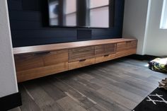 a flat screen tv mounted to the side of a wooden entertainment center in a living room