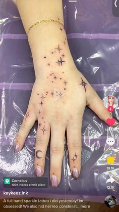 a woman's hand with stars tattooed on it