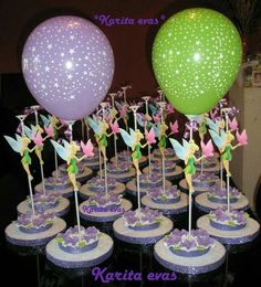 cupcakes with fairy wands and stars on them are displayed in front of balloons