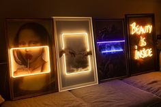 three framed pictures with neon lights on them in a room next to a couch and wall