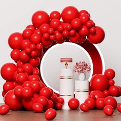 a bunch of red balloons sitting in front of a white plate and some vases