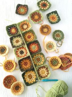 several crocheted grannys and balls of yarn are arranged on a white surface