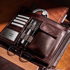 an open brown leather case with glasses and pens