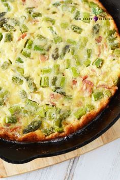 an omelet in a cast iron skillet on a wooden cutting board