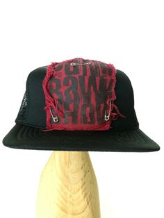 Black foam and mesh trucker hat with Punk Rawk Show maroon red patch pinned on front with safety pins. Distressed fabric on print patch. Otherwise very good used condition. Punk Cap Hat One Size Fits Most, Punk Style Cap Hat, Punk Style Cap One Size Fits Most, Distressed Adjustable Hat For Streetwear, Distressed Cap For Streetwear, Distressed Adjustable Trucker Hat For Streetwear, Vintage Distressed Hat With Flat Brim, Adjustable Distressed Trucker Hat For Streetwear, Vintage Short Brim Hat For Streetwear