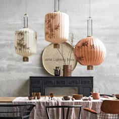 three lanterns hanging from the ceiling above a dining room table