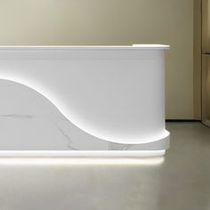 a white counter sitting in the middle of a room next to a wall with lights on it