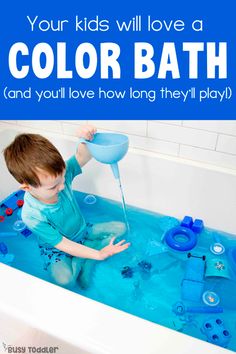 a young boy sitting in a bathtub filled with blue water and playing with toys