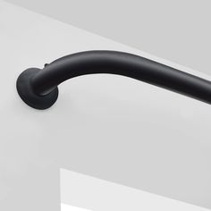 a black handle on the side of a white wall