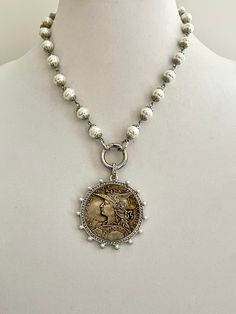 This is gorgeous high luster, white, vintage, porcelain glass, replica freshwater pearl beaded Chain . The reproduction coin pendant, a French Madagascar medal coin is surrounded by Cubic Zirconia stones and pearls. It elegantly hangs from a silver spring lock clasp. The bale attached to the coin is also encrusted with CZ stones. A stunning Art Deco inspired piece of jewelry Perfect for a gift or just for yourself:) This listing is for one necklace only - The photograph depicting two necklaces a Pearl Chain Necklace, Silver Spring, Coin Necklace, Pearl Chain, Keep Jewelry, Coin Pendant, Vintage Porcelain, Cz Stone, Beaded Chain