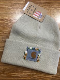 a beanie hat with an american flag patch on the front, and a card attached to it