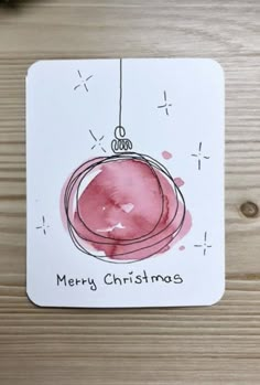 a merry christmas ornament on a wooden table