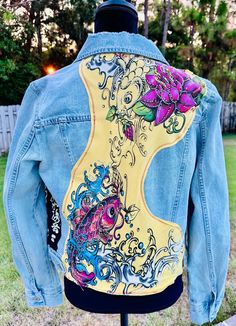 the back of a jean jacket with an image of a fish and flowers on it