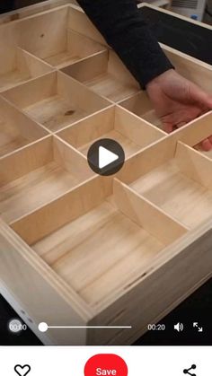 someone is opening up a wooden box with many compartments on the bottom and one in the middle