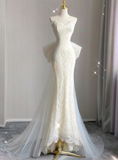 a white wedding dress on display in a room