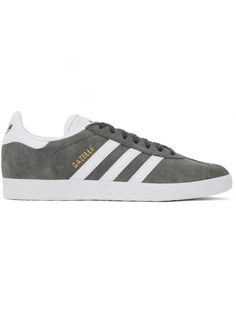 adidas Originals 
Gray & White Gazelle Sneakers 
Low-top nubuck and buffed faux-leather sneakers in gray and white. 
. Lace-up closure 
. Logo embossed at padded tongue 
. Padded collar 
. Signature serrated stripes at sides 
. Logo stamp at outer side 
. Logo bonded at heel tab 
. Padded footbed 
. Mesh lining 
. Textured treaded rubber sole 
Supplier color: Solid grey/White/Gold metallic 
Upper: leather, synthetic. Sole: rubber. 
Made in Viet Nam. 
241751M237065 
Originals Gray & White Gazelle White Gazelle, Casual Athletic Shoes, Logo Stamp, Outdoor Shoes, Leather Sneakers, Gray White, Low Top, White Lace, Adidas Originals