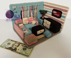 a crocheted couch sitting next to a dollar bill on top of a table