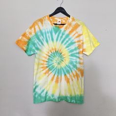 a tie - dyed shirt hanging on a hanger