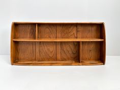 a wooden shelf with four compartments on each side and one section missing the top, against a white background