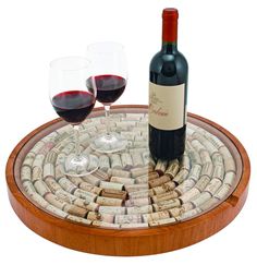 two glasses of red wine are sitting on a cork coaster that is filled with wine