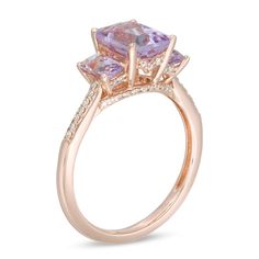 A classic look in romantic color, this gemstone and diamond ring is a stunning accessory she'll wear with everything. Crafted in 14K rose gold, this bold three-stone design showcases a trio of emerald-cut pink quartz - the largest the 8.0 x 6.0mm center stone - each wrapped in a diamond-touched setting. Diamonds line the shank and gallery for an added hint of shimmer. Radiant with 1/6 ct. t.w. of diamonds and a brilliant buffed luster, this choice offers eye-catching style. This ring is availabl Elegant Rose Gold Diamond Ring With Accent Stones, Formal Three Stone Rose Gold Ring, Elegant Rose Gold Three Stone Ring, Formal Rose Gold Three Stone Ring, Elegant 14k Rose Gold Ring With Center Stone, Elegant Rose Gold Three-stone Diamond Ring, Elegant Rose Gold Three Stone Diamond Ring, Classic Rose Gold Birthstone Ring With Diamond Accents, Classic 14k Rose Gold Rings With Accent Stones