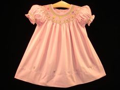 "Favorite / \"heart\" this beautiful dress (add to collection) and get 10% discount coupon  Let's make your Baby Girl look like a Baby Princess ! New hand-made : Boutique Hand-embroidered Bishop Smocked Dress - Blush Pink . Features: All hand-crafted with sophisticated hand-smocking around neck from front to back, plus on the puff sleeves. Adorable hand-embroidery with butterflies & flowers in very beautiful color arranging and interesting details.... Short puffed sleeves. Large hem with approximately 3\" length. 2-3 flower-shaped sweet pink buttons on the upper back of dress. Dress material : 100% deluxe cotton for children comfort. Dress color: beautiful blush Pink . Suggest Retail Price : $190 This style is available in : Size 6M ; Size 12M ; Size 18M ; Size 24M ; Size 2 ; Size 3 ; Size Cute Pink Smocked Dress With Smocked Back, Pink Fitted Dress With Smocked Cuffs, Cute Pink Cotton Smocked Dress, Pink Fitted Smocked Dress With Short Sleeves, Pink Short-sleeved Dress With Smocked Cuffs, Pink Short Sleeve Dress With Smocked Cuffs, Pink Cotton Smocked Dress With Short Sleeves, Fitted Pink Embroidered Smocked Dress, Fitted Pink Smocked Dress With Embroidery