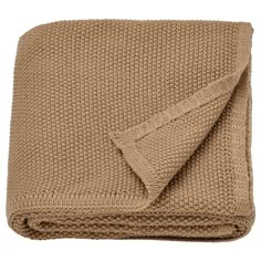 the blanket is folded up on top of it's back and has a brown knitted edge