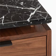 a black marble top on a wooden drawer