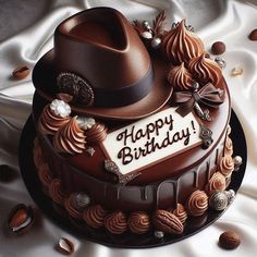 a birthday cake with chocolate frosting, decorations and a hat on top that says happy birthday