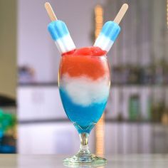 two red, white and blue ice cream popsicles in a glass on a table