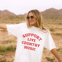 Support Live Music Shirt, Country Music Shirt, Country Concert TShirt, Country Music Tee, Western Graphic Tee, Country Music Gift .: 100% ring-spun cotton .: Medium fabric (6.1 oz/yd² (206.8 g/m .: Relaxed fit .: Sewn-in twill label Shipping & Processing:  Please allow 1-7 business days for processing. It may be processed sooner, and you will be updated as soon as it ships. Shipping can take anywhere from 2-5 business days.  Returns & Exchanges: We do not offer returns or exchanges due to items being made to order. Please refer to size chart to get the fit you want. If there is any problem with your order, please let us know within 2 weeks of receiving your item. Thanks for shopping with Daring & Darling! Band Merch Shirt With Slogan For Concerts, White Band Merch T-shirt For Music Festivals, White Tops With Band Logo For Music Festivals, Band Merch T-shirt With Slogan For Music Festivals, Music Festival Concert T-shirt With Text Print, Band Merch Tops For Country Concerts, White Music-themed T-shirt With Band Logo, White T-shirt With Text Print For Music Festivals, Text Print T-shirt For Music Festivals And Concerts