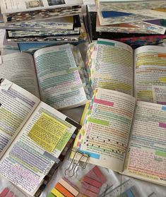 several open books on a table with colored papers