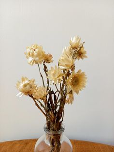 a vase filled with yellow flowers on top of a wooden table