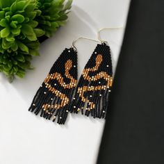 These handmade beaded snake fringe earrings are a striking addition to any jewelry collection. With their unique serpent design and intricate beadwork, they bring a touch of tribal and bohemian flair to any outfit. The fringe detail adds movement and elegance, making these earrings a true statement piece. Perfect for those who love bold and unique accessories, these earrings are versatile enough to complement both casual and dressy attire. Whether as a gift or a personal indulgence, these snake- Unique Black Snake-shaped Jewelry, Unique Black Beaded Dangle Earrings, Black Artisan Beaded Chain Jewelry, Artisan Black Beaded Chain Jewelry, Black Beaded Chain Earrings As A Gift, Unique Handmade Black Beaded Earrings, Handmade Black Snake-shaped Jewelry, Unique Black Beaded Earrings With Dangling Beads, Black Bohemian Beaded Chain Earrings