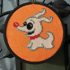 an orange cross stitch with a dog on it