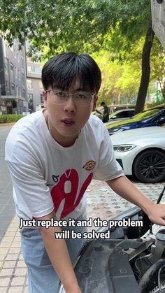 a young man standing next to an open car hood with the words, just replace it and the problem will be solved