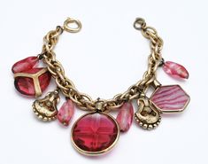 For your consideration is this vintage Red art glass cha cha dnagle charm bracelet . It consist of a gold plated chain with red and pinkish art glass and gold ornate charms. The bracelet is Accessocraft . Accessocraft design costume jewelry in NYC from 1930 to 1998. This piece has the look of the 1960s -1970s The statment cha cha bracelet is 7 1/2 inches long with a spring ring clasp the bracelet is in good vintage condition Thank you very much for stopping by . Please feel free to email (CONVO)