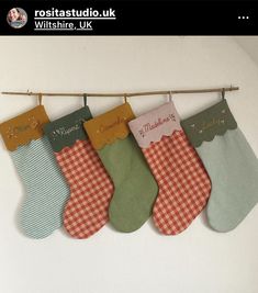 five christmas stockings hanging from a clothesline with the words merry christmas written on them