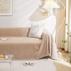 a living room with a couch, coffee table and lamp on the wall next to it