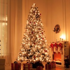 a white christmas tree with presents under it