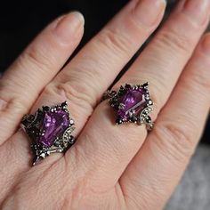 a woman's hand with two rings on top of her finger and one ring in the shape of a heart