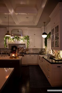 a kitchen filled with lots of counter top space and lights on the ceiling above it