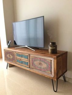 an old tv stand has been decorated with hand painted drawers