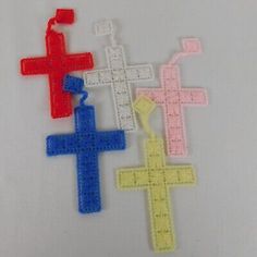 three different colored plastic crosses on a white surface