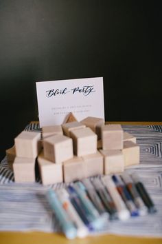 a table topped with lots of wooden blocks next to a sign that says black party