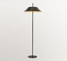 the floor lamp has a black shade on it's base and is next to a white wall