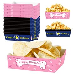 a pink box filled with lots of chips next to a pile of cookies and crackers